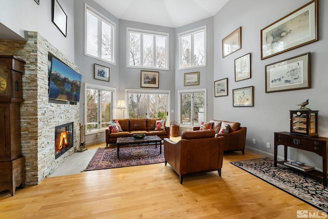 6350 Green Ranch Rd, Reno, NV 89519 - living room with a stone fireplace, plenty of natural light, wood finished floors, a towering ceiling, and baseboards