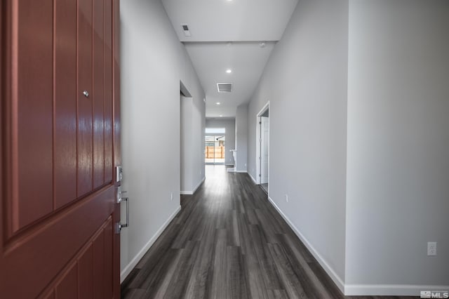 corridor with dark wood finished floors, recessed lighting, and baseboards