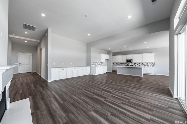unfurnished living room featuring dark wood-style floors, recessed lighting, and baseboards