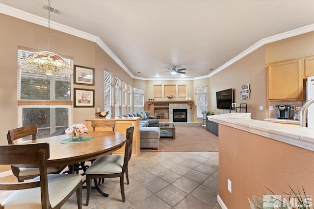 1556 Diamond Country Dr, Reno, NV 89521 - dining room featuring ceiling fan, ornamental molding, a chandelier, a glass covered fireplace, and light carpet