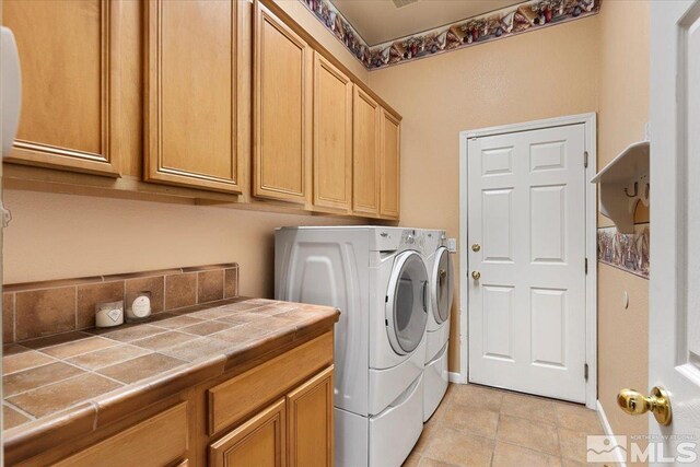 1556 Diamond Country Dr, Reno, NV 89521 - laundry room with washing machine and dryer, cabinet space, and light tile patterned flooring