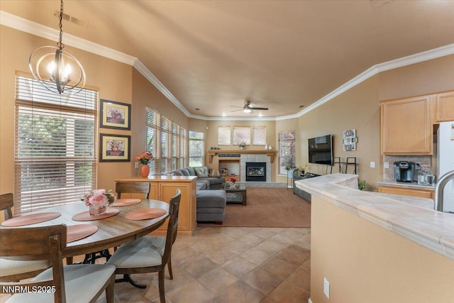 1556 Diamond Country Dr, Reno, NV 89521 - dining area with a ceiling fan, ornamental molding, a tiled fireplace, and light carpet