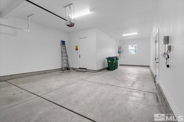 garage featuring a garage door opener and baseboards
