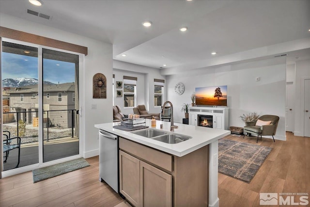 3631 Pulsar Ln Unit 1, Carson City, NV 89705 - kitchen featuring a sink, open floor plan, stainless steel dishwasher, a glass covered fireplace, and a center island with sink