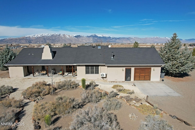 10 Dee Ct, Smith Valley, NV 89444 - view of front of home featuring a mountain view, driveway, a garage, and stucco siding