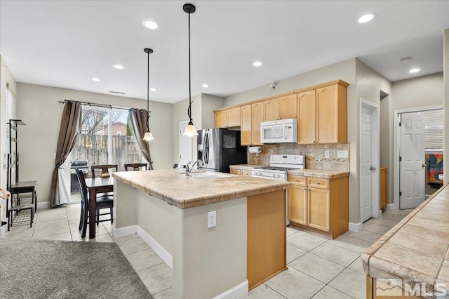 1950 Red Willow Dr, Reno, NV 89521 - kitchen featuring white appliances, light brown cabinets, a sink, light tile patterned flooring, and decorative backsplash