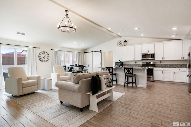 276 Greywall Ct, Dayton, NV 89403 - living room with light wood-style flooring, a chandelier, a barn door, and recessed lighting