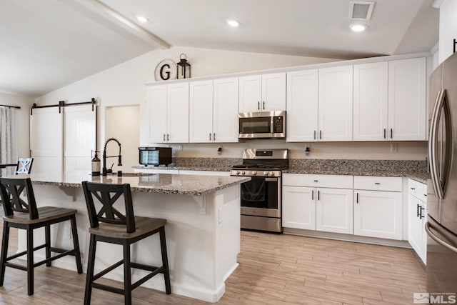 276 Greywall Ct, Dayton, NV 89403 - kitchen with appliances with stainless steel finishes, white cabinetry, stone countertops, and a breakfast bar area