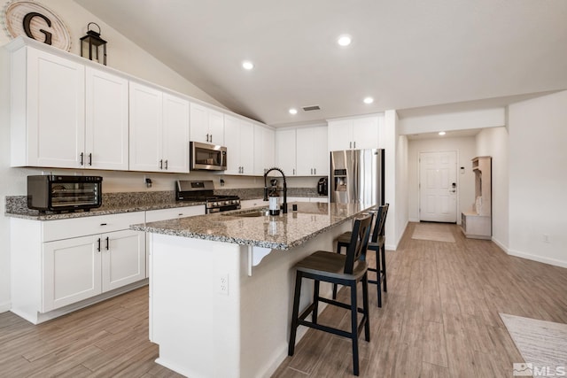 276 Greywall Ct, Dayton, NV 89403 - kitchen with stainless steel appliances, a sink, a breakfast bar area, baseboards, and dark stone counters