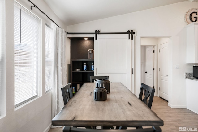 276 Greywall Ct, Dayton, NV 89403 - dining area with lofted ceiling, light wood-style flooring, a barn door, and baseboards