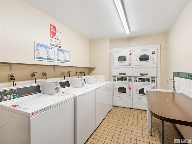 2450 Lymbery St Unit 213, Reno, NV 89509 - community laundry with stacked washing machine and dryer, washer and clothes dryer, and light tile patterned floors