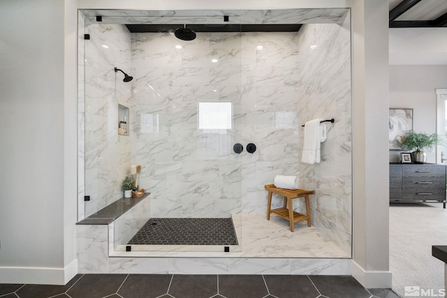 bathroom with a marble finish shower, baseboards, and tile patterned floors