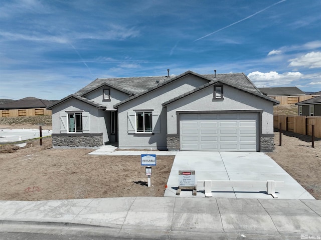 ranch-style house with stucco siding, an attached garage, fence, concrete driveway, and a tiled roof