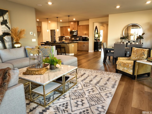 living area with dark wood-style flooring and recessed lighting