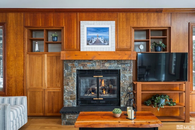 living area featuring wood finished floors, radiator heating unit, and a stone fireplace