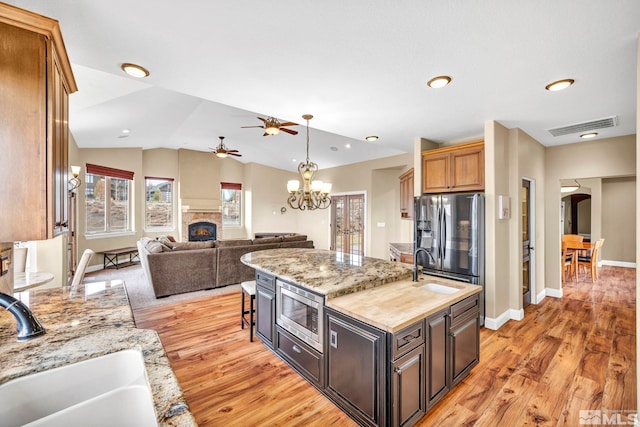 227 S Earlham, Reno, NV 89511 - kitchen with a sink, ceiling fan, a center island with sink, stainless steel appliances, and a lit fireplace