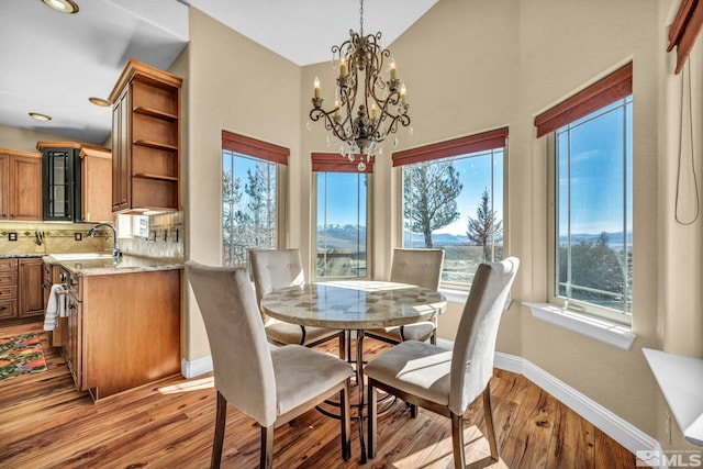 227 S Earlham, Reno, NV 89511 - dining area with light wood-type flooring, baseboards, a chandelier, and high vaulted ceiling