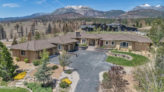 227 S Earlham, Reno, NV 89511 - view of front of home featuring a garage, a mountain view, stucco siding, and driveway