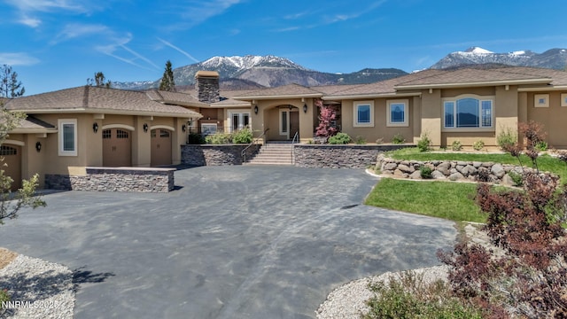 227 S Earlham, Reno, NV 89511 - view of front facade with stucco siding, a mountain view, an attached garage, and a chimney