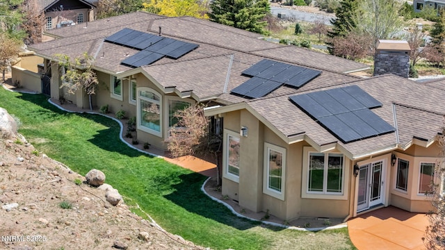 227 S Earlham, Reno, NV 89511 - rear view of house featuring stucco siding, roof with shingles, roof mounted solar panels, and a lawn