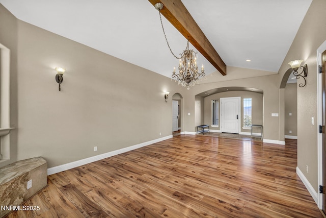 227 S Earlham, Reno, NV 89511 - unfurnished living room featuring arched walkways, wood finished floors, a chandelier, and baseboards