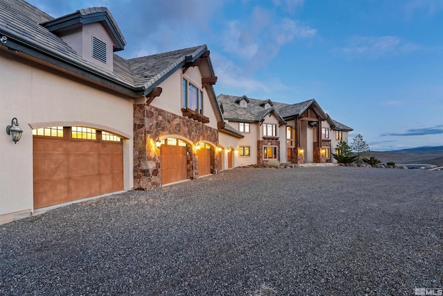 525 Cable Canyon Way, Fernley, NV 89408 - view of side of home featuring stone siding, driveway, and stucco siding
