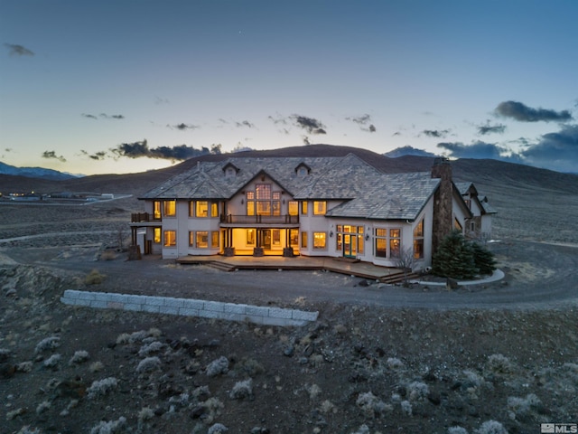 525 Cable Canyon Way, Fernley, NV 89408 - rear view of house with a balcony, a deck with mountain view, and a chimney