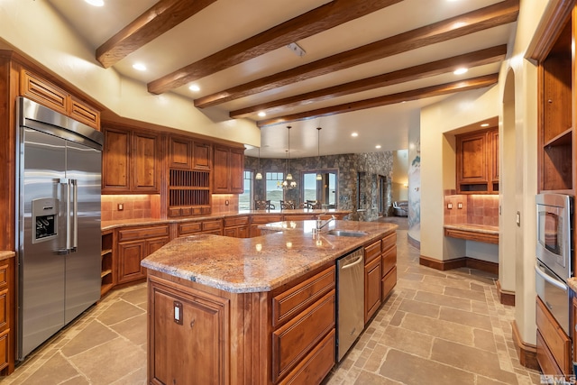 525 Cable Canyon Way, Fernley, NV 89408 - kitchen featuring stainless steel appliances, a sink, brown cabinets, light stone counters, and tasteful backsplash