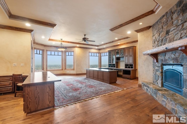 525 Cable Canyon Way, Fernley, NV 89408 - living room featuring crown molding, a tray ceiling, light wood-style floors, a ceiling fan, and a fireplace