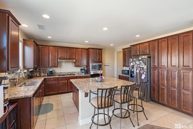 2780 Tobiano Dr, Reno, NV 89521 - kitchen featuring stainless steel appliances, a sink, a center island, under cabinet range hood, and a breakfast bar area
