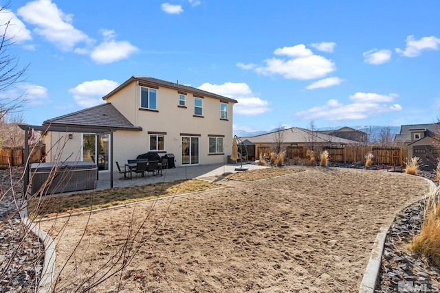2780 Tobiano Dr, Reno, NV 89521 - rear view of property with a fenced backyard, a hot tub, a patio, and stucco siding