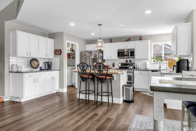953 Julia Ln, Fernley, NV 89408 - kitchen featuring appliances with stainless steel finishes, tasteful backsplash, white cabinets, a breakfast bar area, and recessed lighting