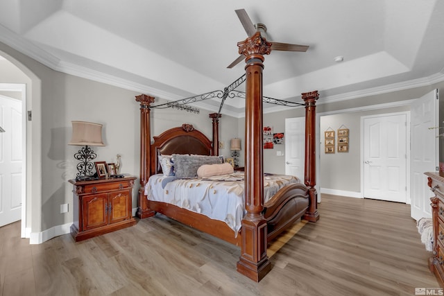 953 Julia Ln, Fernley, NV 89408 - bedroom featuring arched walkways, a tray ceiling, crown molding, light wood-style flooring, and baseboards