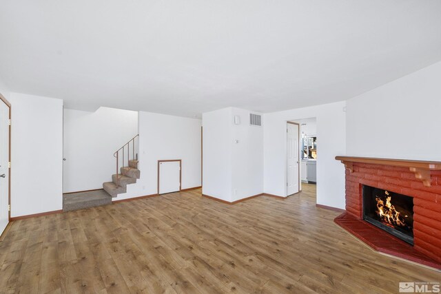 857 Cherry Tree Dr Unit 3, Sparks, NV 89434 - unfurnished living room featuring stairs, wood finished floors, a brick fireplace, and baseboards