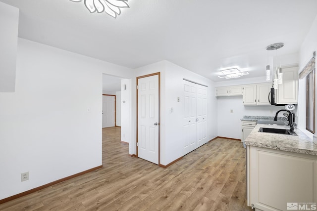 857 Cherry Tree Dr Unit 3, Sparks, NV 89434 - kitchen with light wood finished floors, a sink, baseboards, and white cabinetry