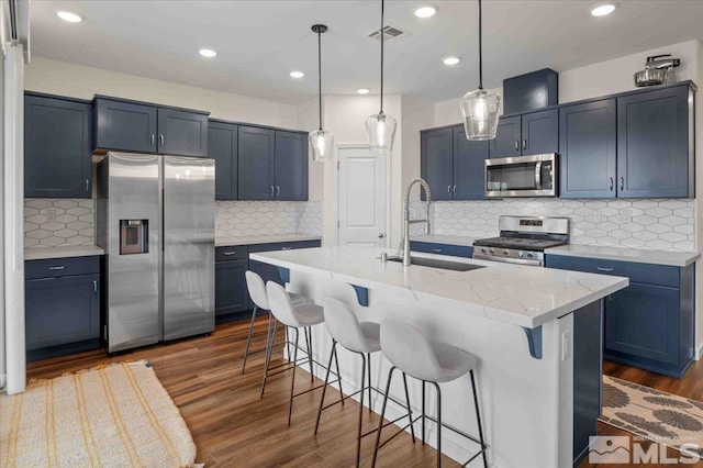 7192 Discovery Ln, Reno, NV 89506 - kitchen with appliances with stainless steel finishes, a sink, backsplash, a kitchen breakfast bar, and dark wood finished floors