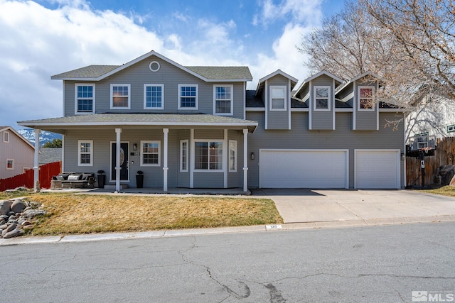 view of front of house featuring an attached garage, driveway, fence, and roof with shingles