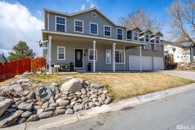 view of front of house featuring fence, driveway, an attached garage, and a porch