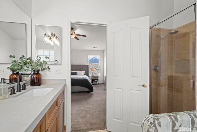 ensuite bathroom featuring ceiling fan, a stall shower, and vanity