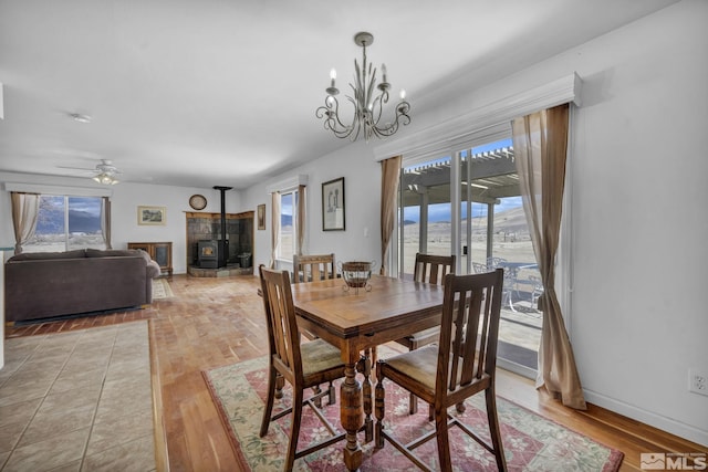 6100 Sage Flat Rd, Reno, NV 89510 - dining area featuring a wood stove, light wood-type flooring, a chandelier, and a ceiling fan