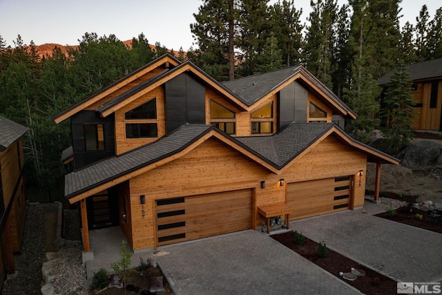 contemporary home featuring decorative driveway and an attached garage