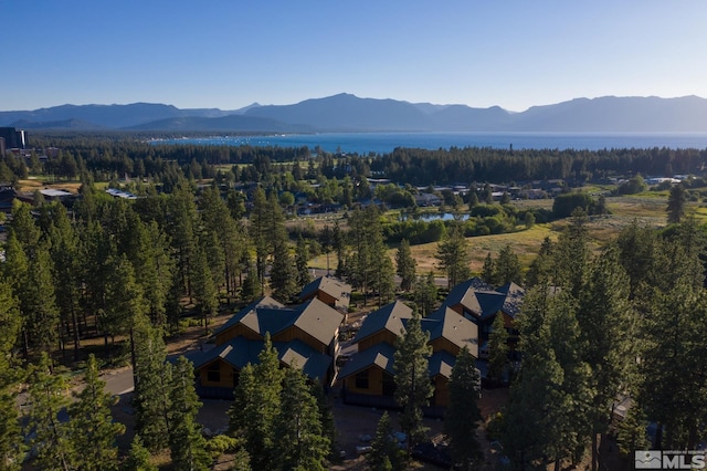 view of property location with a mountain backdrop and a forest