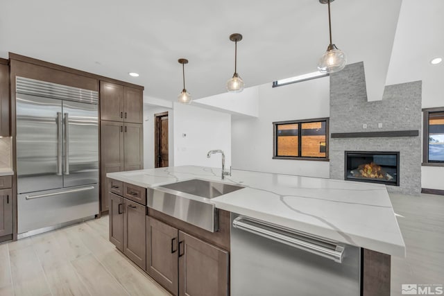 kitchen with appliances with stainless steel finishes, a sink, open floor plan, pendant lighting, and recessed lighting