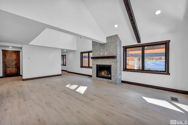 unfurnished living room with high vaulted ceiling, a stone fireplace, baseboards, beamed ceiling, and wood finished floors