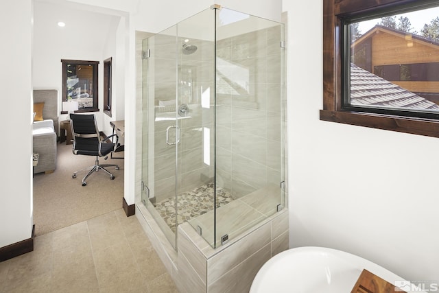 full bathroom featuring a stall shower, a freestanding tub, and tile patterned flooring