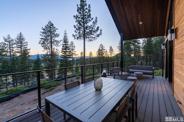 deck at dusk with outdoor dining space