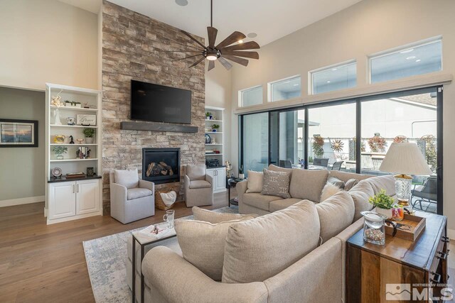721 Marewood Trl, Reno, NV 89511 - living room with high vaulted ceiling, a ceiling fan, wood finished floors, plenty of natural light, and a fireplace