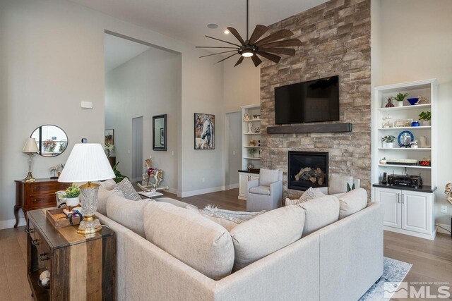 721 Marewood Trl, Reno, NV 89511 - living room featuring a ceiling fan, high vaulted ceiling, a fireplace, light wood-style floors, and baseboards