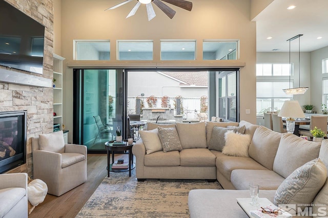721 Marewood Trl, Reno, NV 89511 - living area with a high ceiling, a ceiling fan, wood finished floors, a fireplace, and recessed lighting