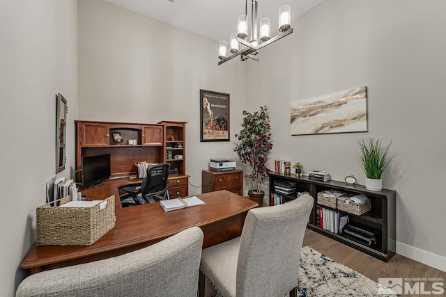 721 Marewood Trl, Reno, NV 89511 - office area featuring a chandelier, baseboards, a towering ceiling, and wood finished floors